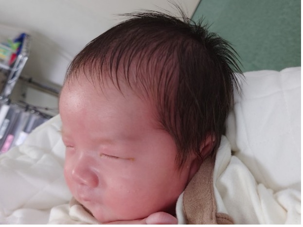 生後1か月健診の日、母親に抱っこされる赤ちゃんの様子