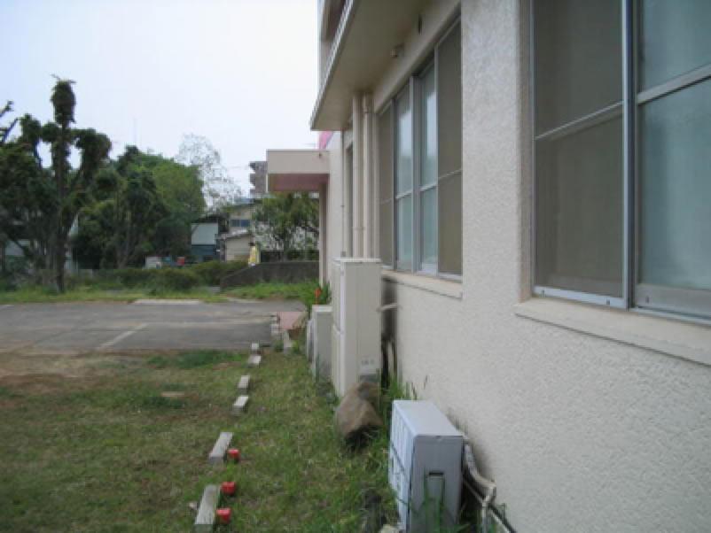 測量用の杭が打たれた建物脇の敷地