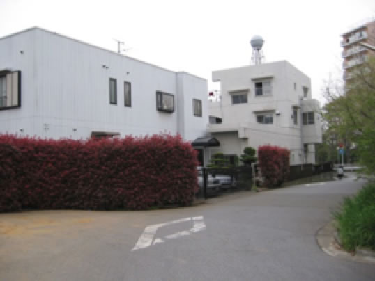 赤い植え込みと駐車スペースがある建物