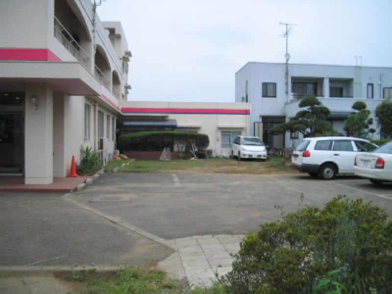 完成したピンクのラインの診療所建物と駐車場