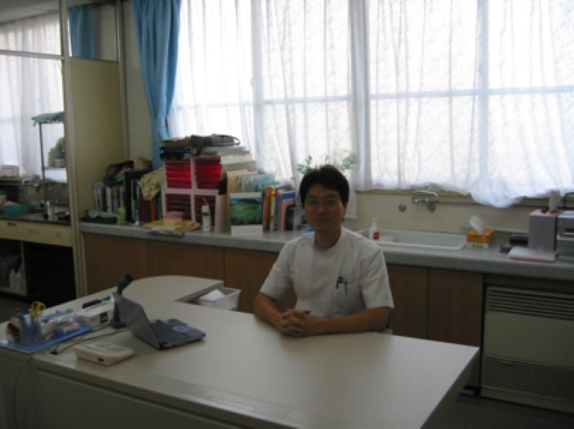 事務所の机に座る男性