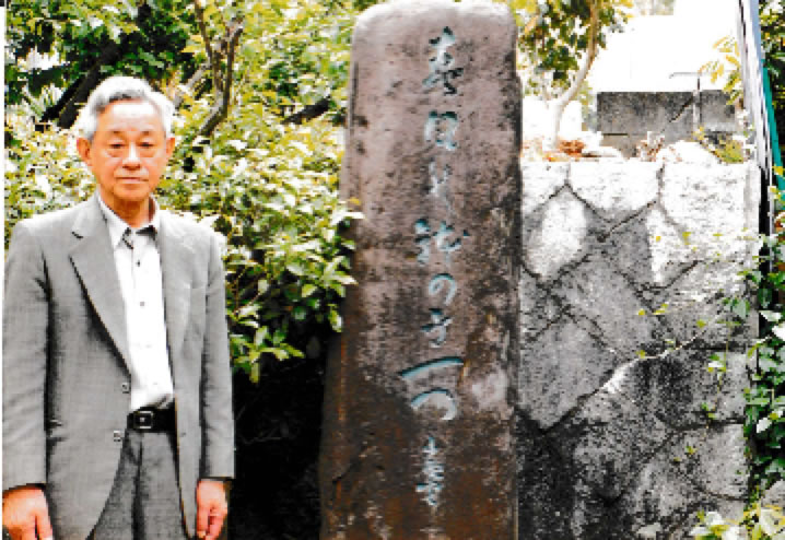 石碑の前に立つ年配の男性