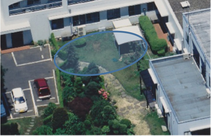 建物の屋上に楕円で範囲が示された航空写真