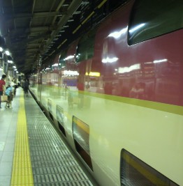 夜の駅ホームに停車する赤い電車