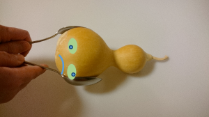 黄色いひょうたん型のおもちゃを持つ手