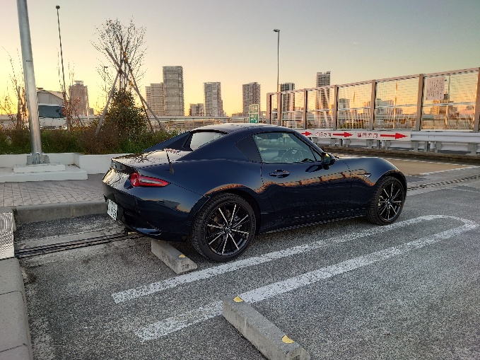 橋の上に停められた青いオープンカーの写真