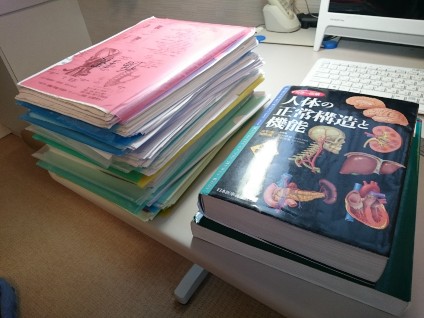 机に積まれた医学書とノート