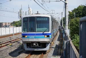住宅街を走る青いラインの電車