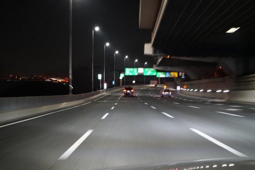 夜間の高速道路、高架下を走行する車内からの写真