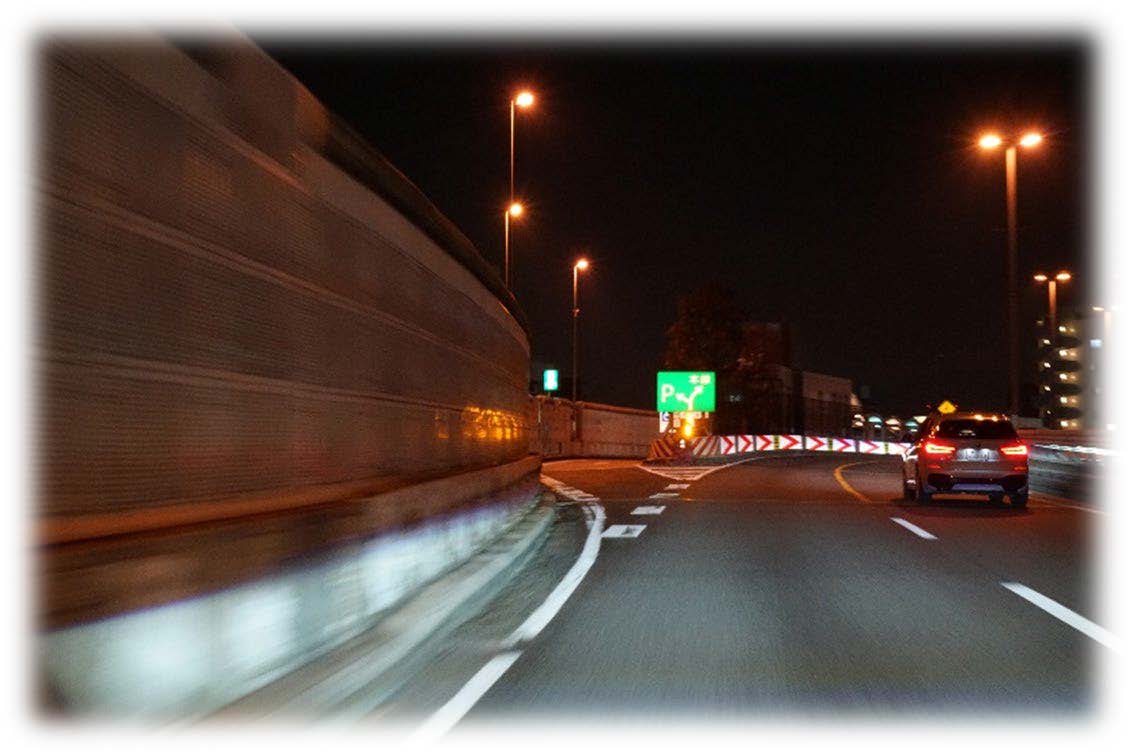 緑の出口標識が見える夜の高速道路