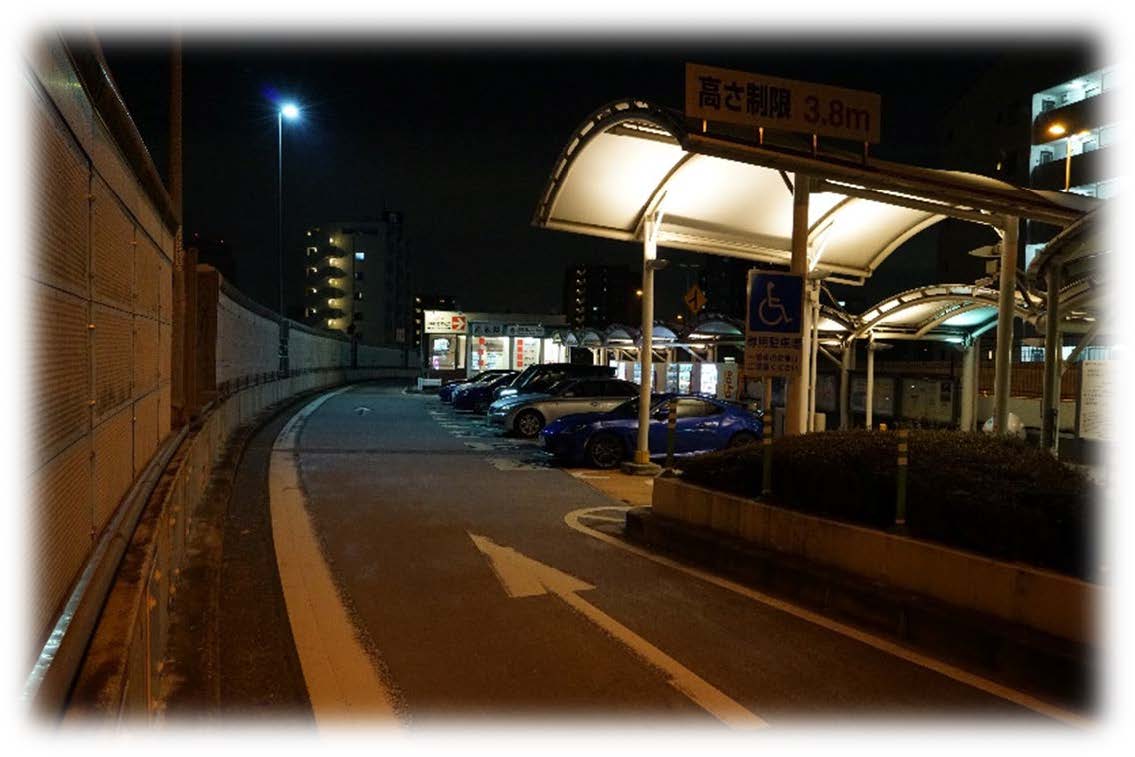 夜の駐車場とバス停のような屋根付き施設
