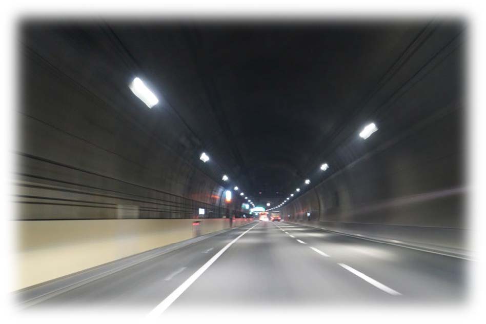夜のトンネル内を走行する車の光跡写真