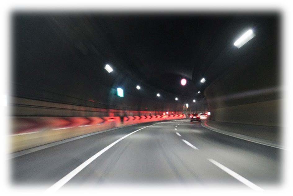 赤いテールランプの光跡が写るトンネル内の写真
