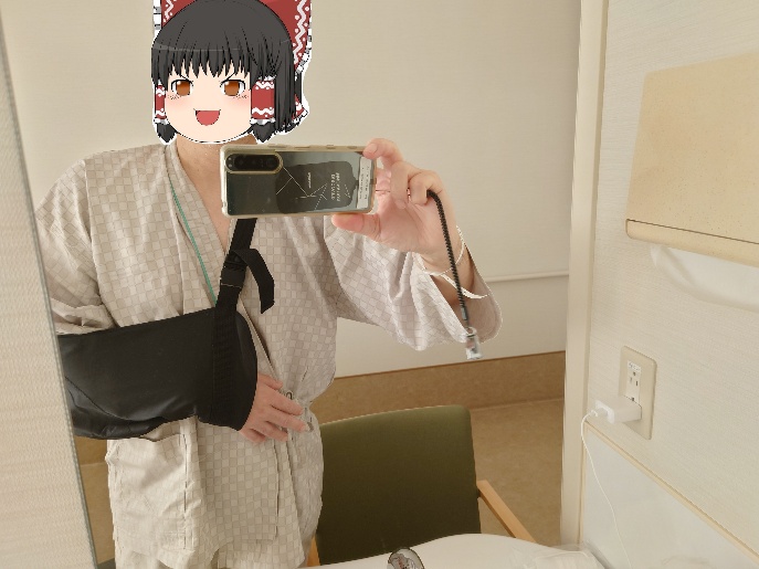 腕を三角巾で固定し鏡越しに自撮りする写真