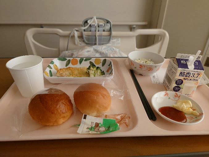 パンと副菜が並ぶ病院の朝食トレーの写真