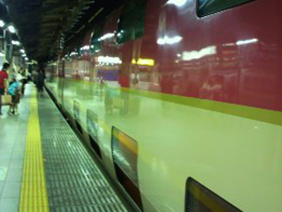 夜の駅ホームに停車する赤い電車